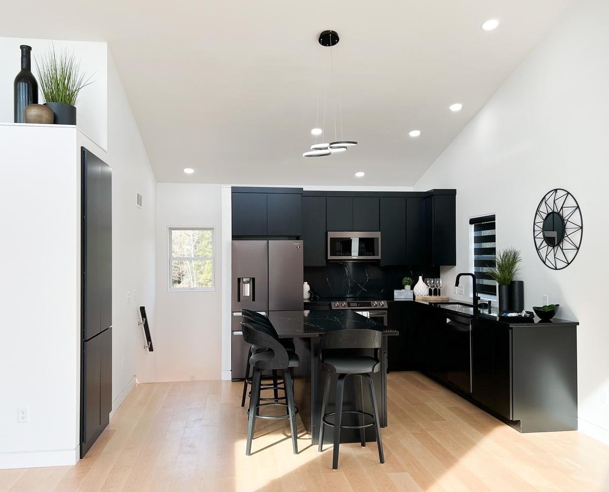 Open concept black kitchen with island in Marathon, WI custom home by Ross Construction.