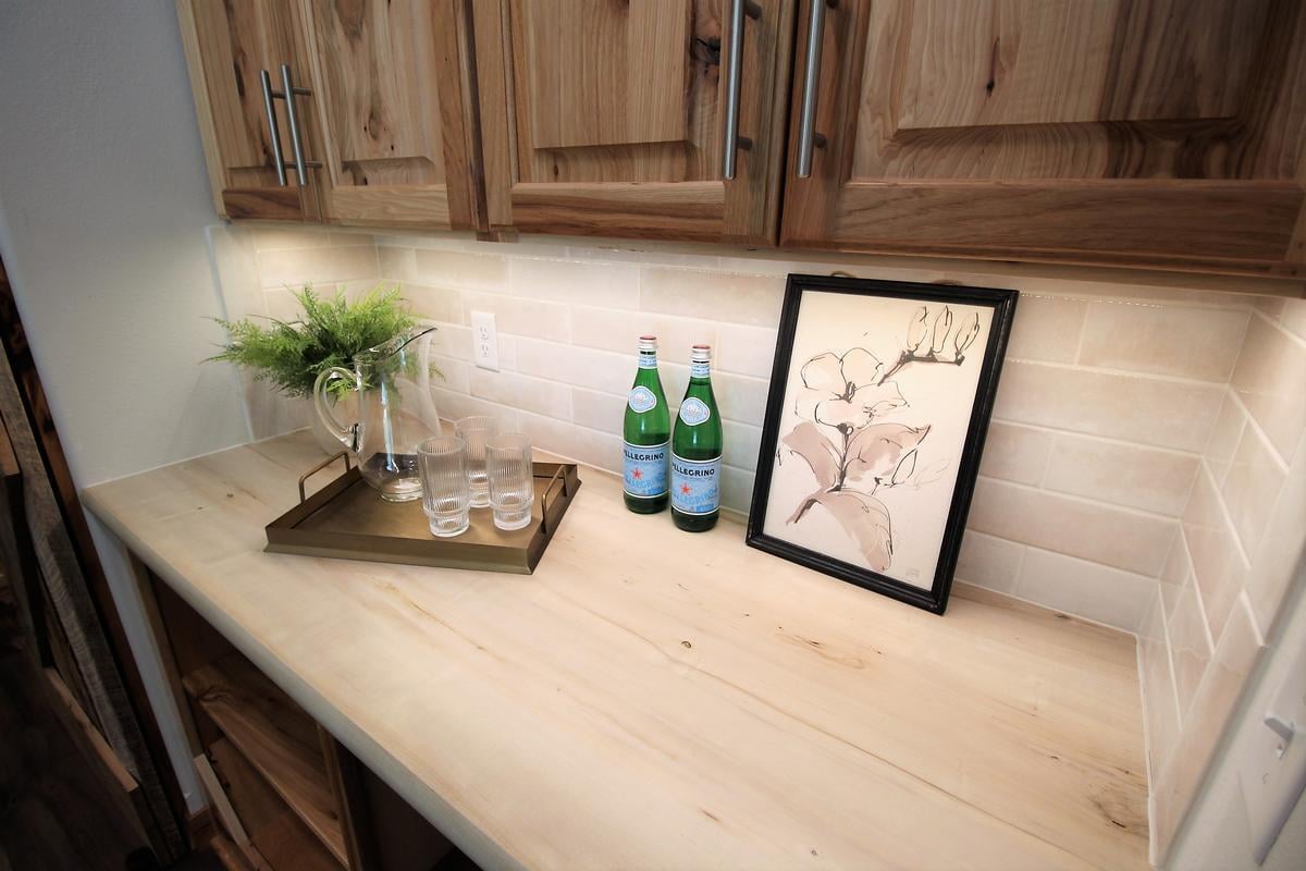 Beverage station with natural wood cabinets and subway tile backsplash in a Ross Construction home in Lake Dubay, WI.