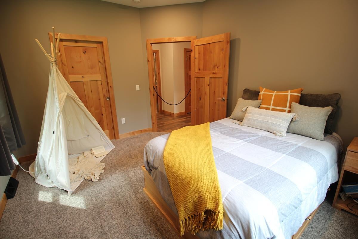 Kid-friendly bedroom with tent play area and wood accents in a custom home by Ross Construction in Wausau, WI.
