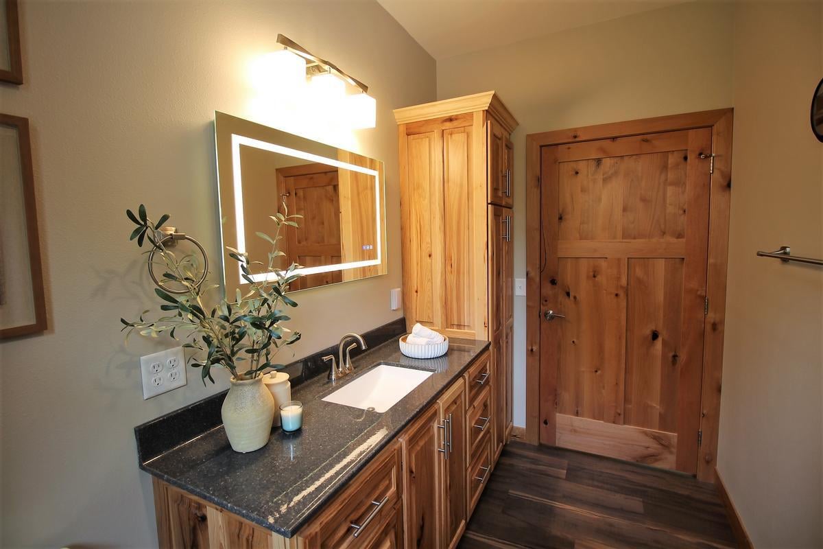 Single-sink bathroom design with wood cabinetry by Ross Construction in Wausau, WI.