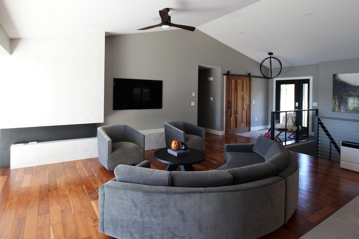 Contemporary living room with gray seating and flat-screen TV by Ross Construction in Edgar, WI.