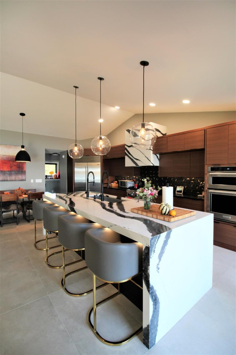Kitchen island with bar seating and waterfall countertop by Ross Construction in a custom Edgar, WI home.