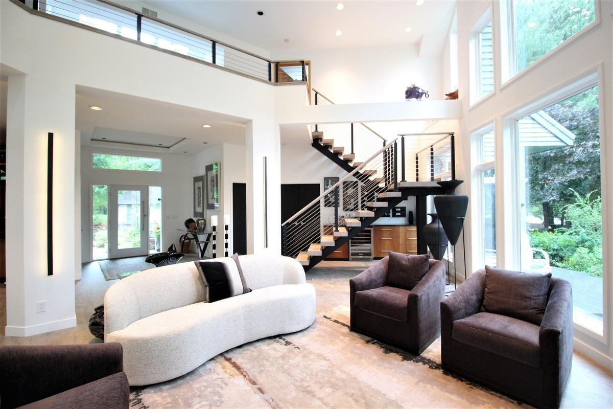 Bright two-story living room with floor-to-ceiling windows in Wausau custom home by Ross Construction.
