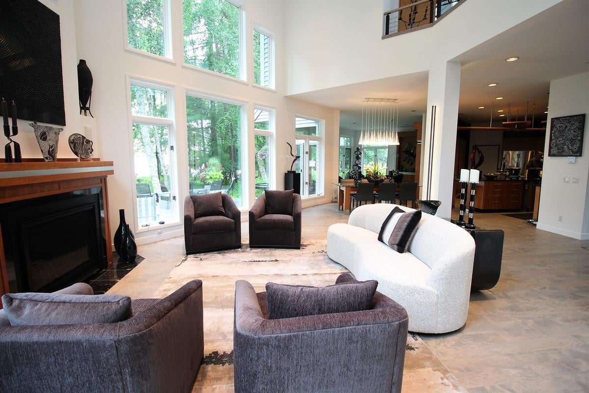 Light-filled custom home living space with fireplace and garden views in Rib Mountain by Ross Construction.