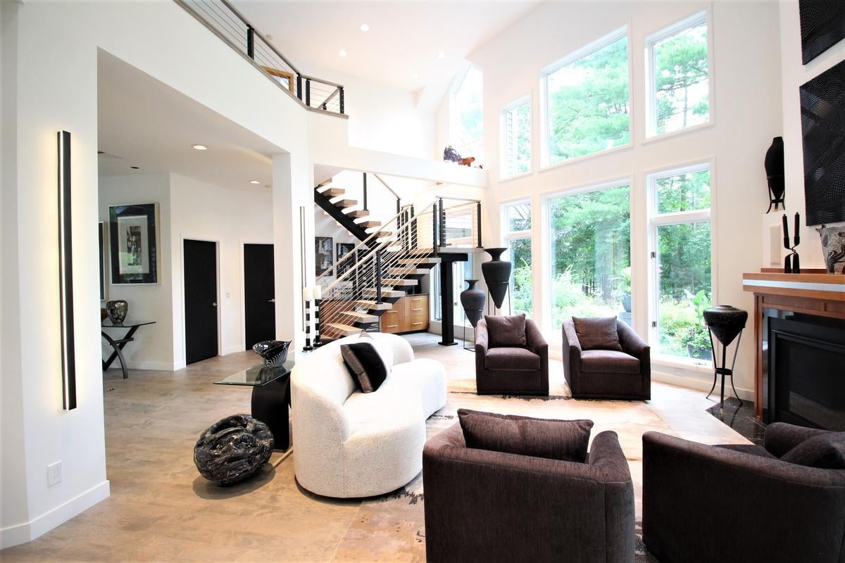 Open living room with floating staircase and dramatic ceiling height in Lake Dubay custom home by Ross Construction.
