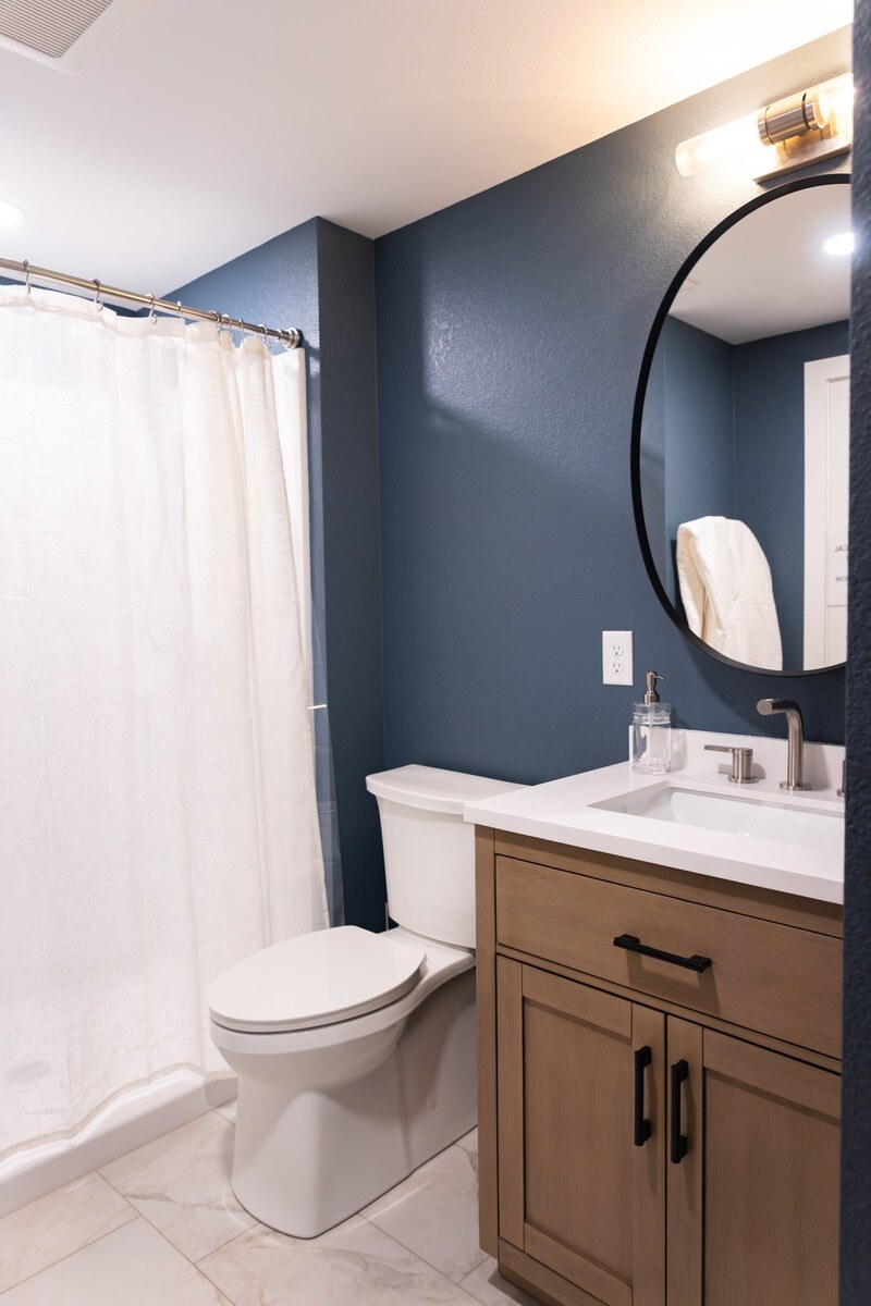whole home remodel bathroom with wood vanity and tub shower curtain full view minocqua wi