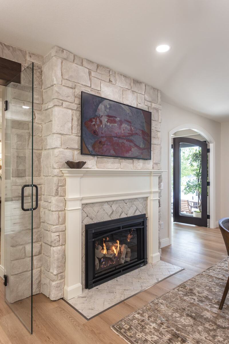 whole home remodel dining room stone fireplace with arched door to patio minocqua wi