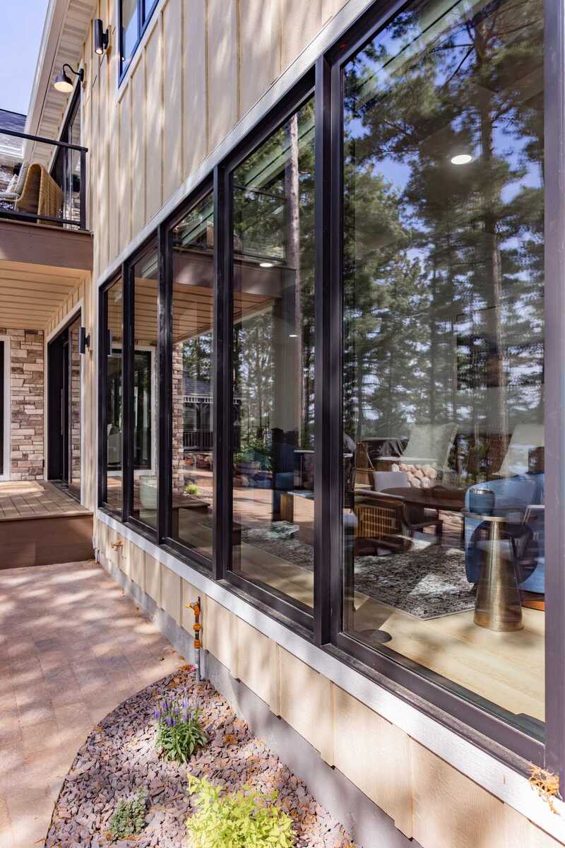 whole home remodel exterior black window wall with board and batten siding and paver walkway minocqua wi