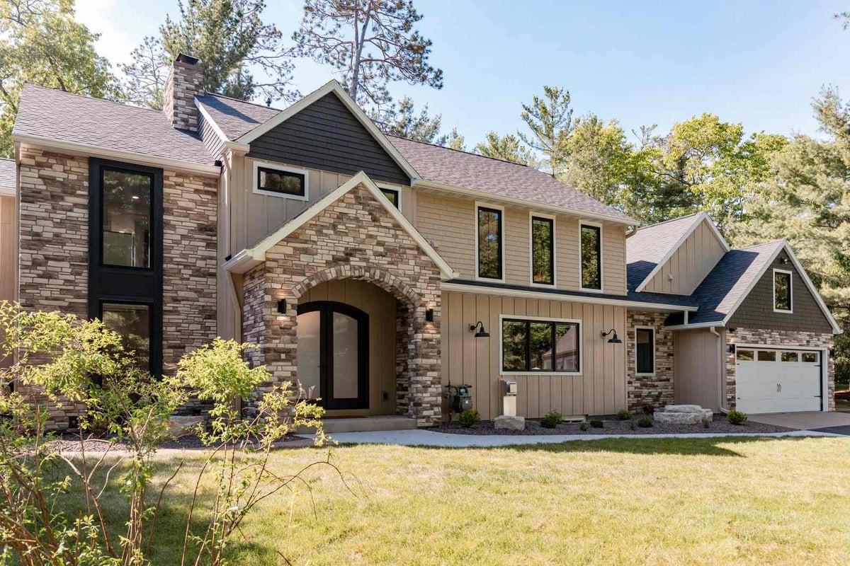 whole home remodel exterior front elevation angled view with stone chimney and garage minocqua wi