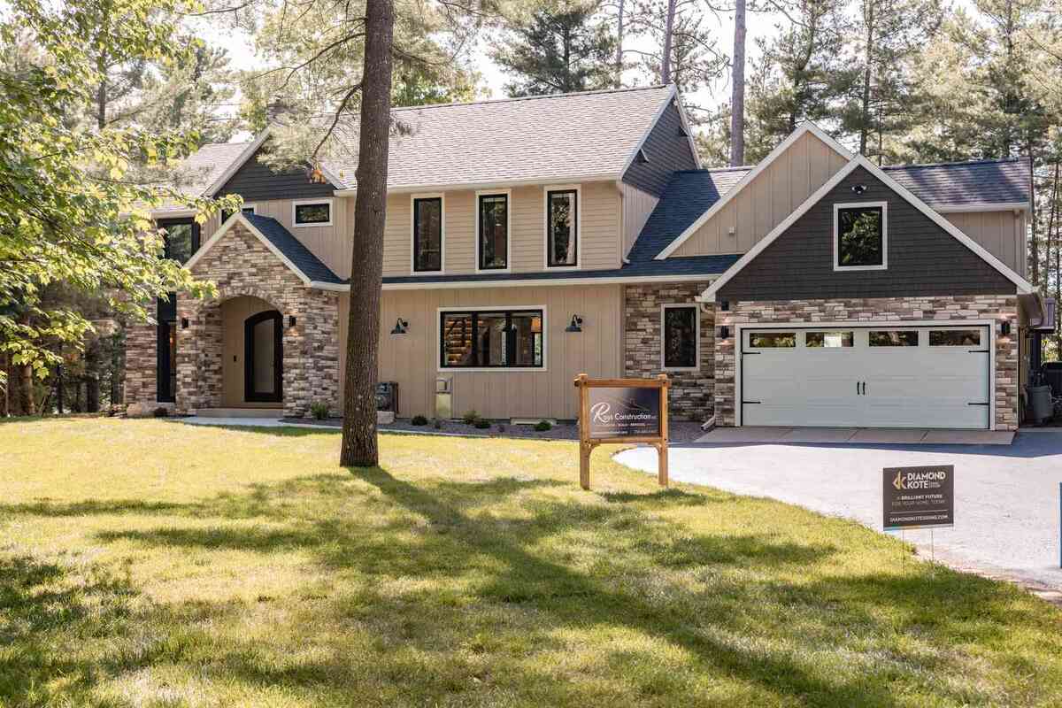 whole home remodel exterior front elevation with lawn and two car garage minocqua wi