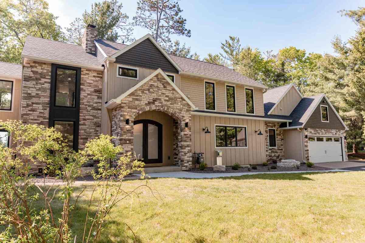 whole home remodel exterior front elevation with stone arched entry minocqua wi