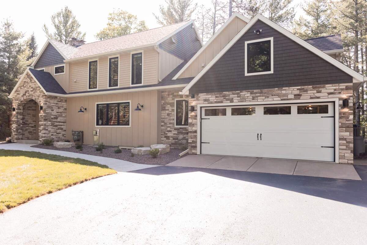 whole home remodel exterior front view with driveway and garage minocqua wi