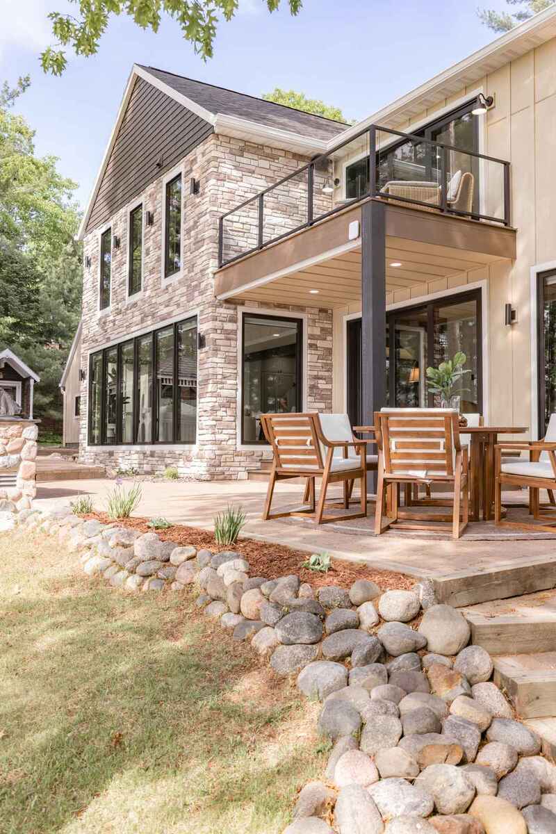 whole home remodel exterior rear elevation with balcony and fieldstone border minocqua wi