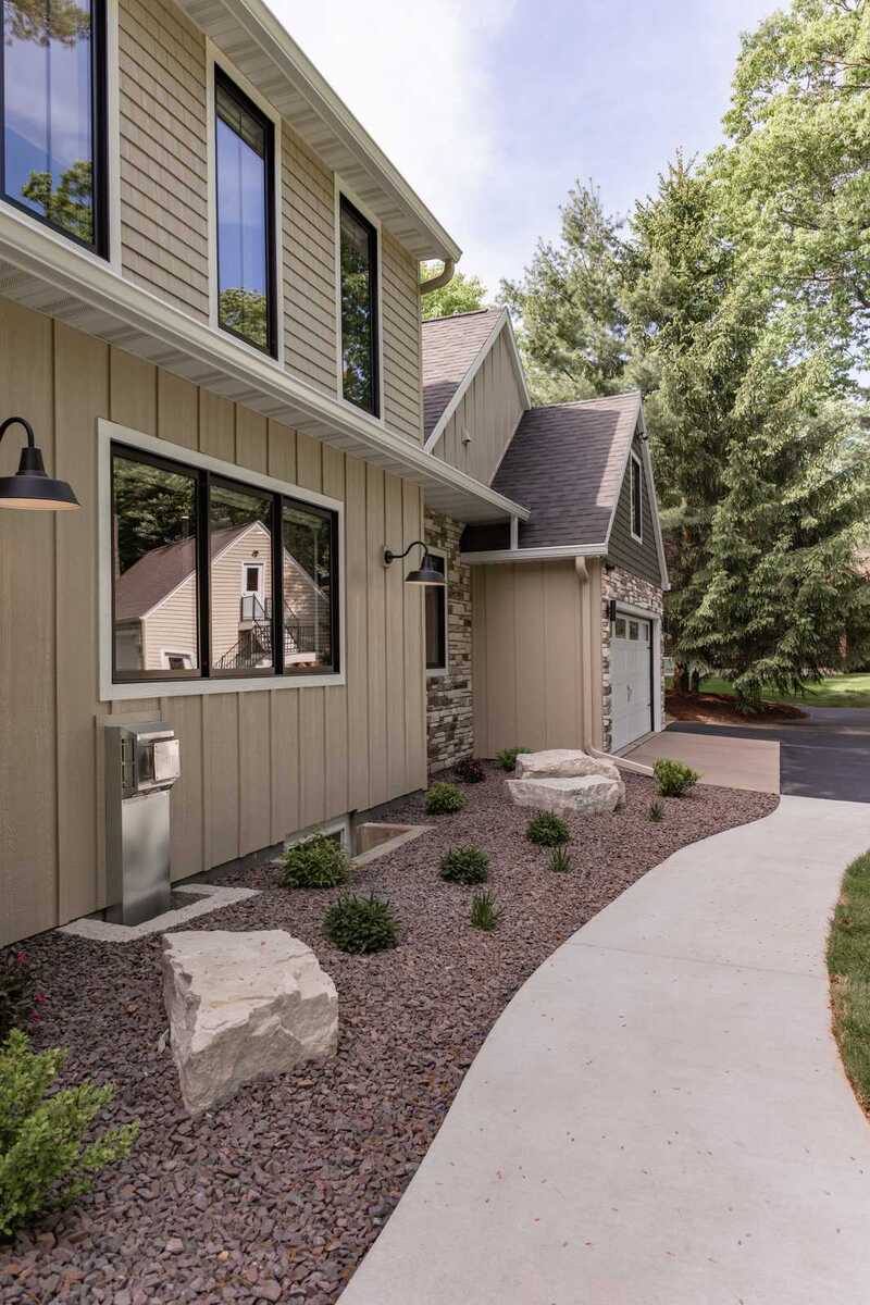 whole home remodel exterior side walkway with landscape boulders and barn lights minocqua wi
