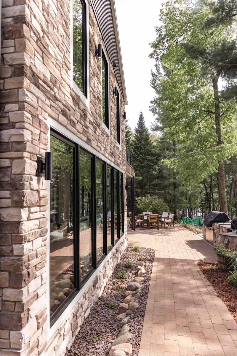 whole home remodel exterior stone side walkway with black windows minocqua wi