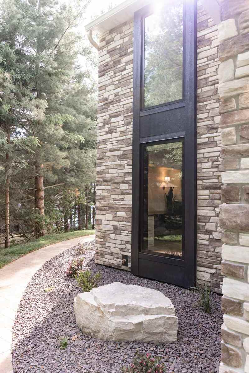 whole home remodel exterior tall black windows in stone tower minocqua wi