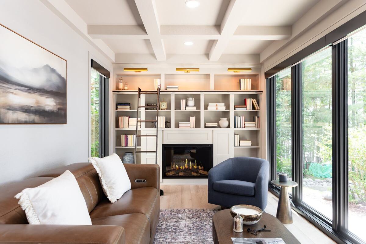 whole-home-remodel-library-with-leather-sofa-and-wall-of-windows-minocqua-wi