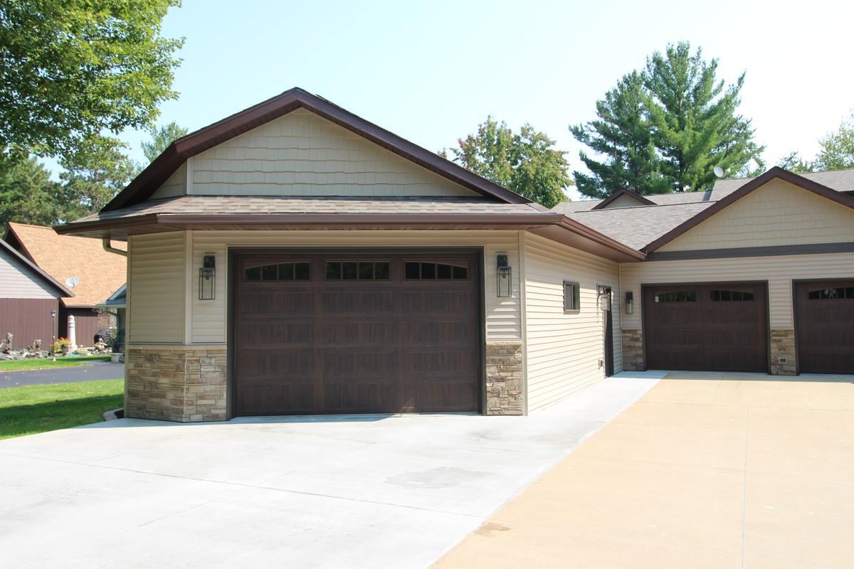 Three-stall garage with stone and siding exterior by Ross Construction in Marathon, WI.