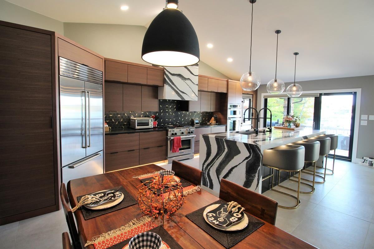 Bold kitchen with waterfall island and geometric backsplash in a Lake Dubay, WI custom home by Ross Construction.