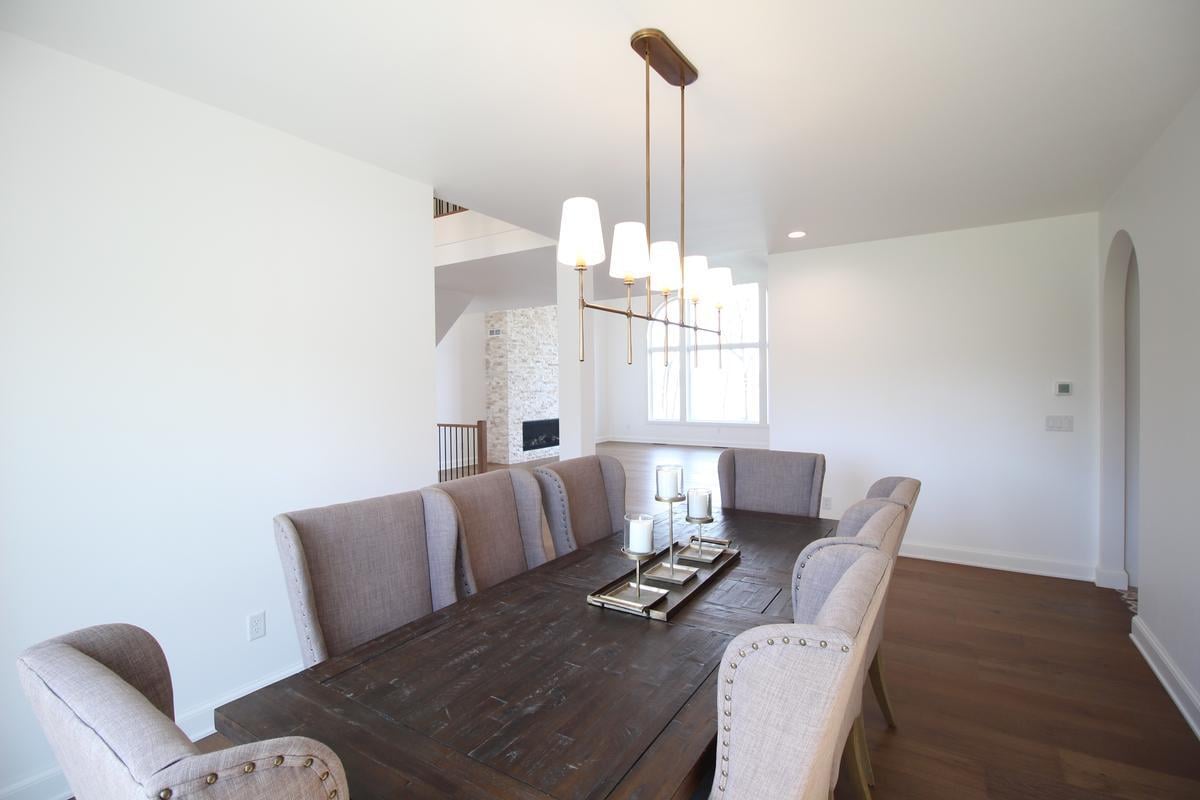 Elegant dining room with upholstered chairs and gold pendant lighting by Ross Construction in Marathon, WI