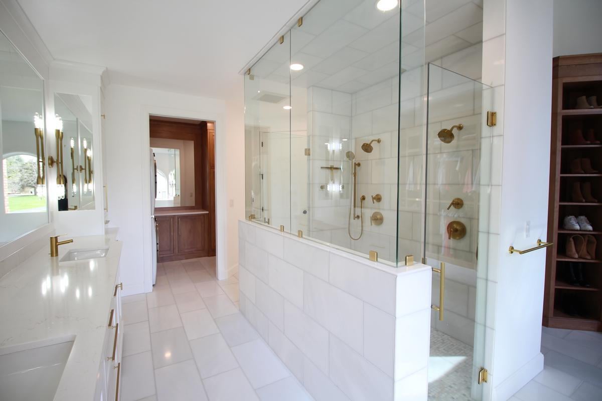 Spacious walk-in shower with glass enclosure and gold fixtures in a custom home by Ross Construction in Wausau, WI