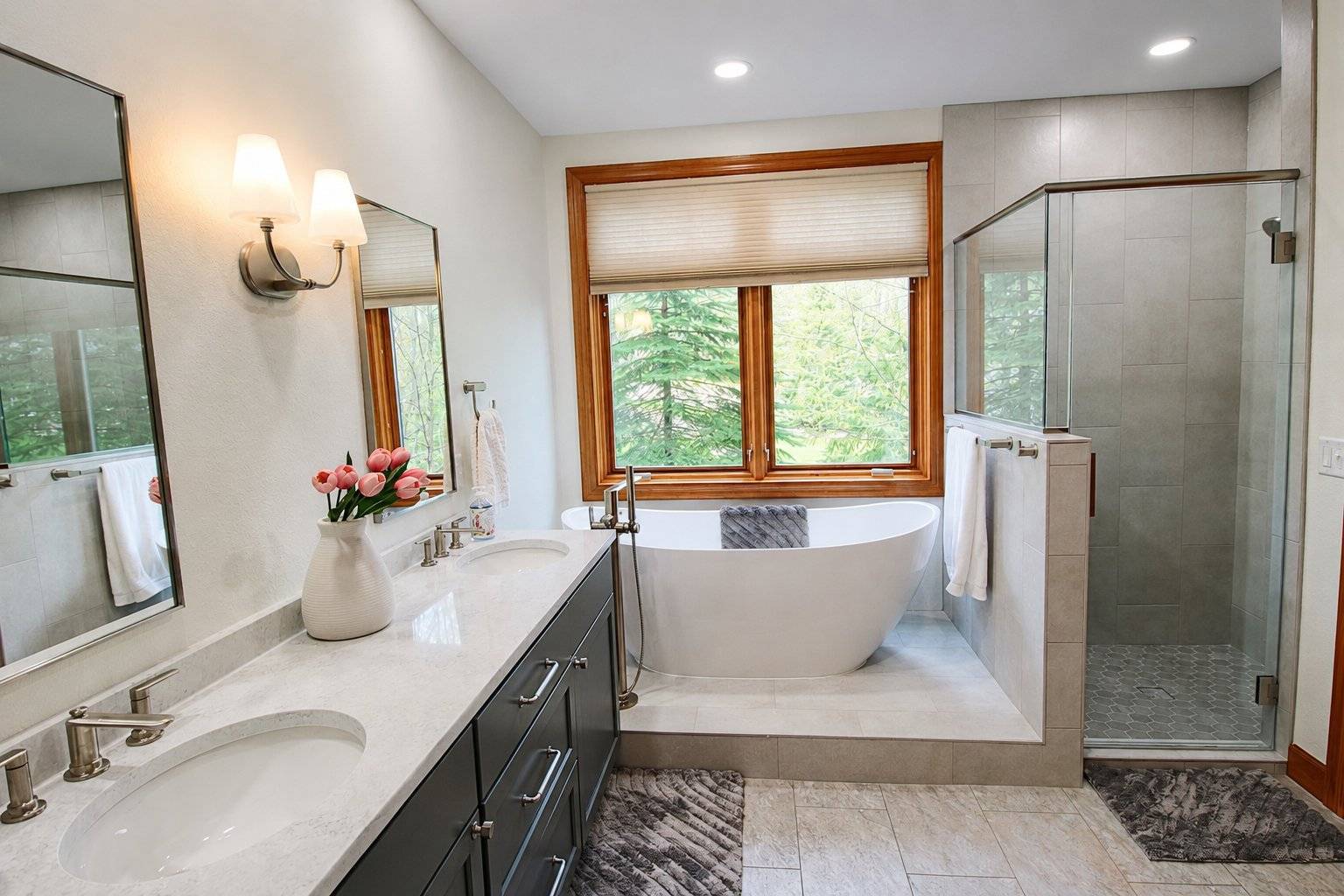 bathroom remodel double vanity gray cabinets freestanding tub wood framed window glass shower