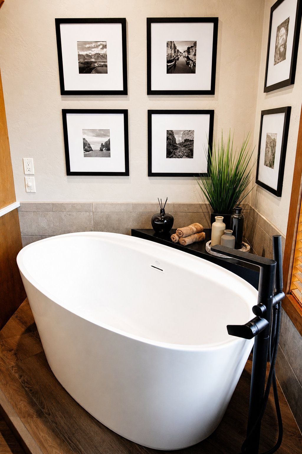 bathroom remodel freestanding tub black filler gallery wall wood platform
