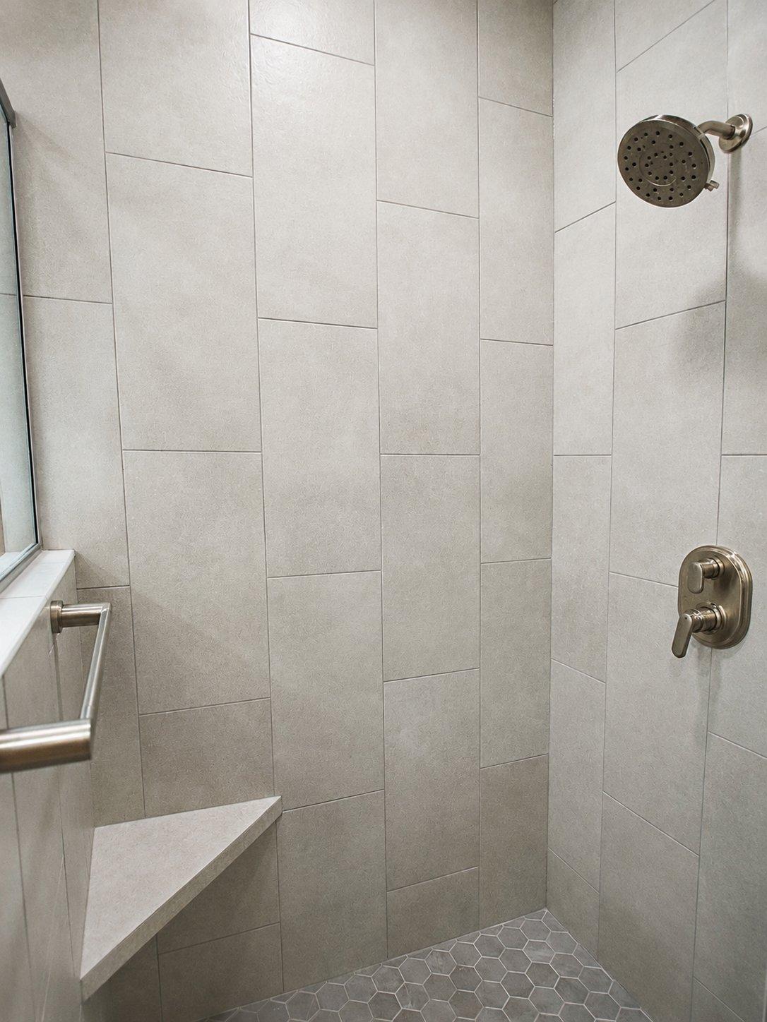 bathroom remodel walk-in shower light gray tile corner bench brushed nickel showerhead