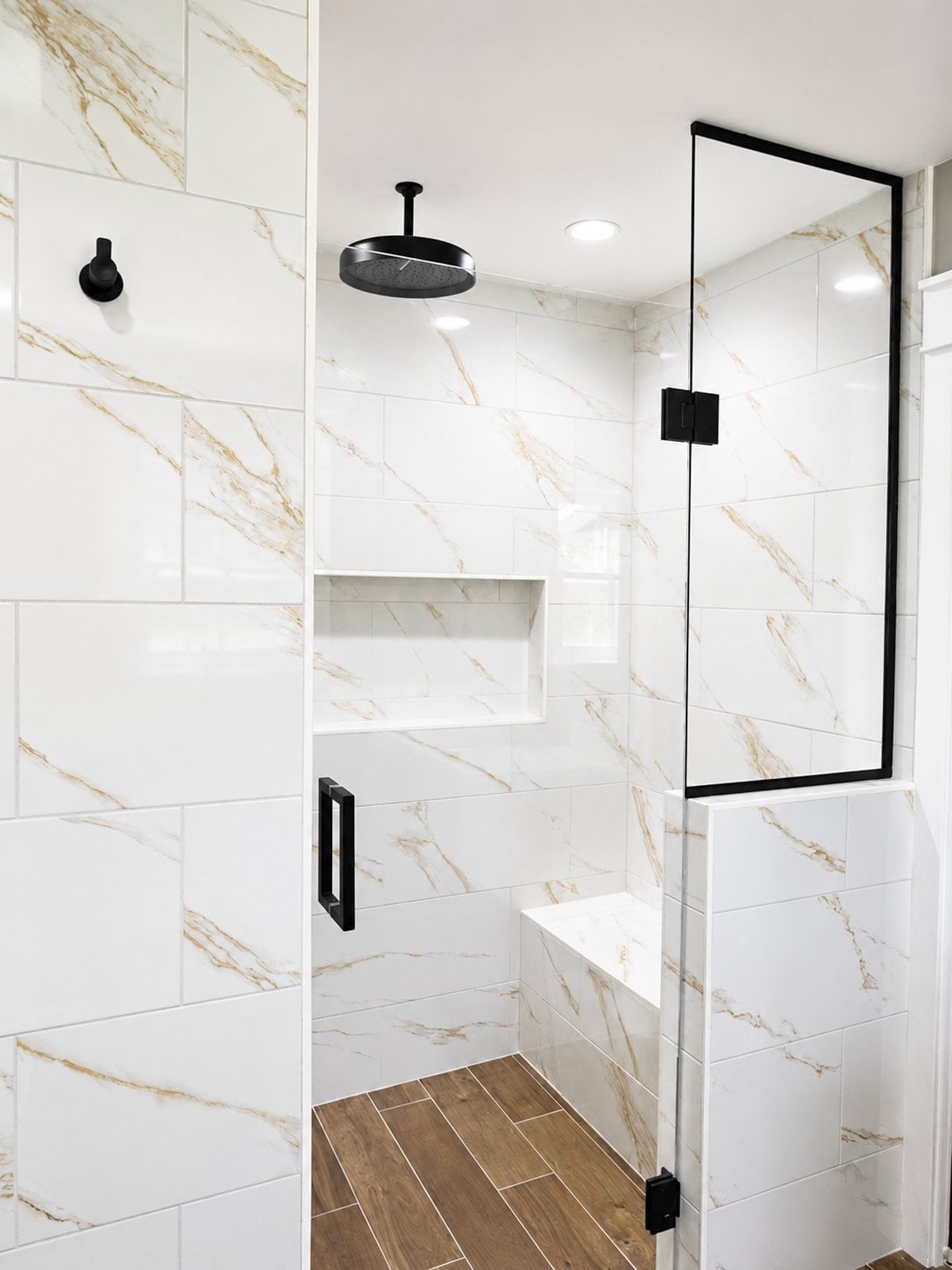 bathroom-remodel-walk-in-shower-interior-marble-tile-rain-head-built-in-bench-black-hardware