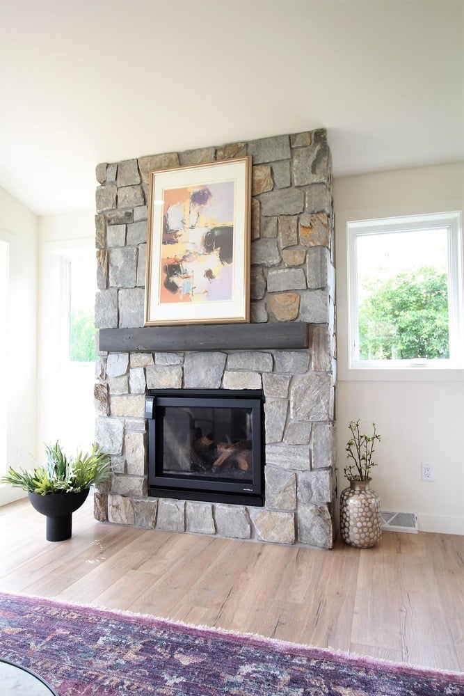 Custom stone fireplace with abstract art centerpiece in a Ross Construction home in Rib Mountain, WI. Custom stone fireplace with abstract art centerpiece in a Ross Construction home in Rib Mountain, WI.