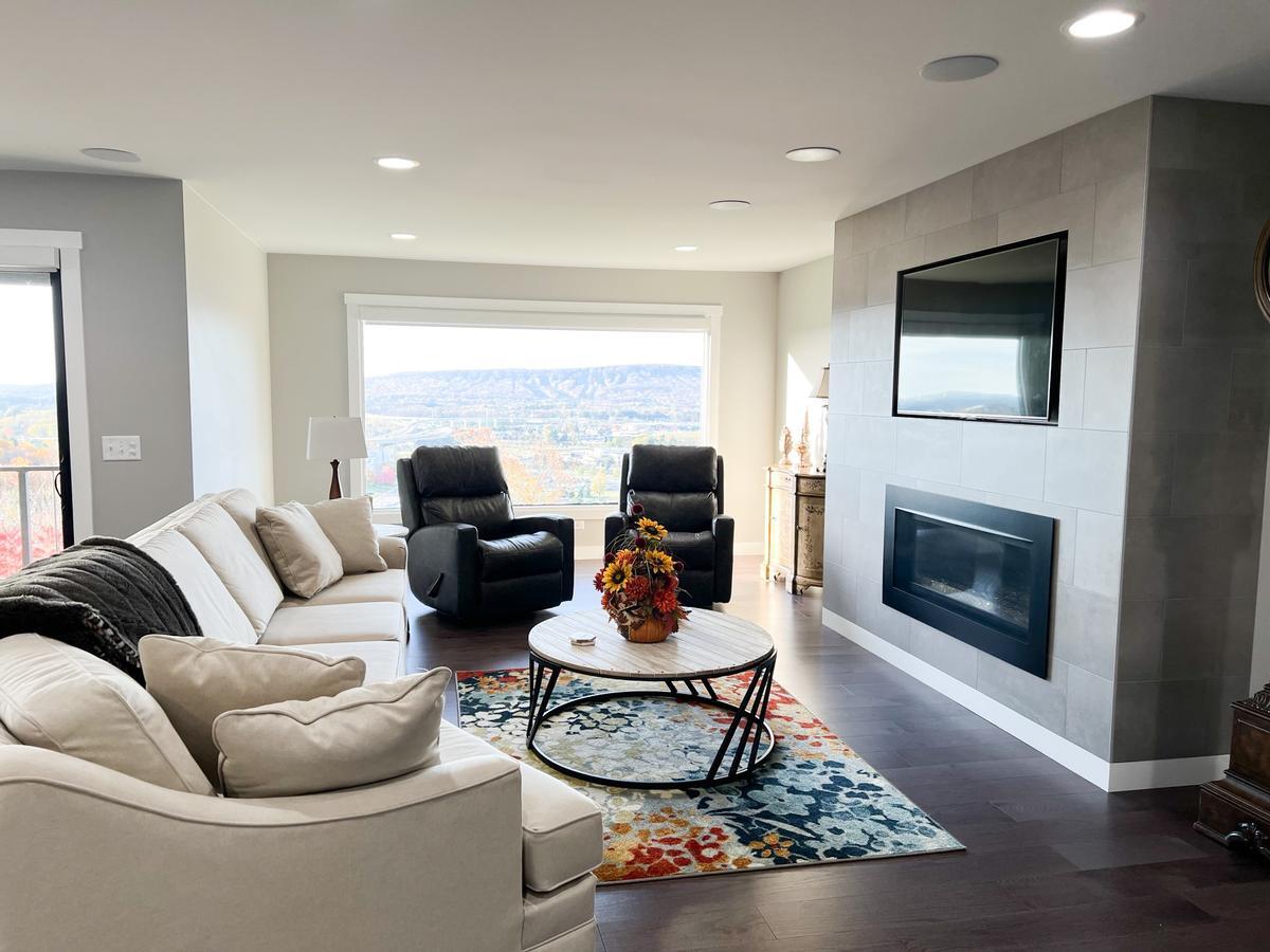 Living room with mountain views and modern fireplace in Rib Mountain custom home by Ross Construction.