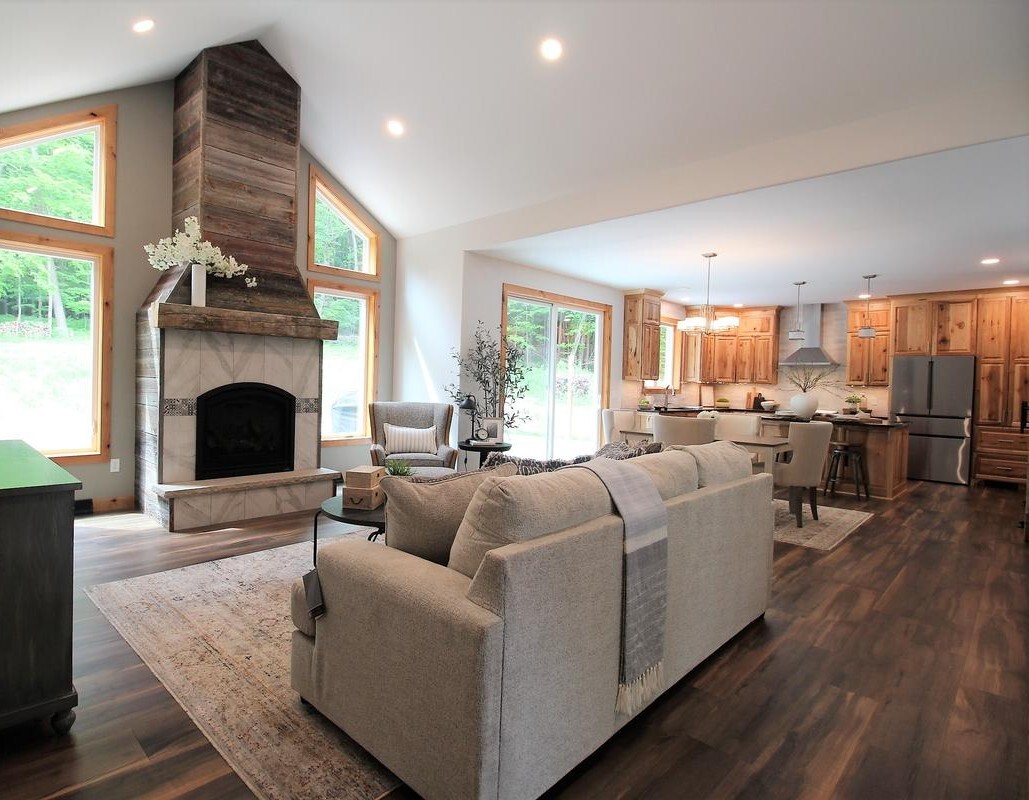 Custom home great room with rustic fireplace and high ceilings in Rib Mountain, WI by Ross Construction.