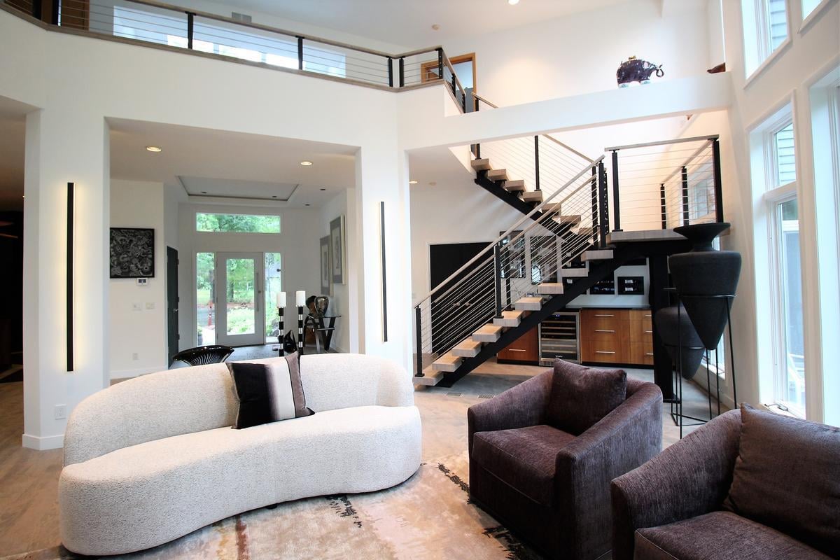 Contemporary open-concept living area with sleek floating stairs in Wausau custom home by Ross Construction.