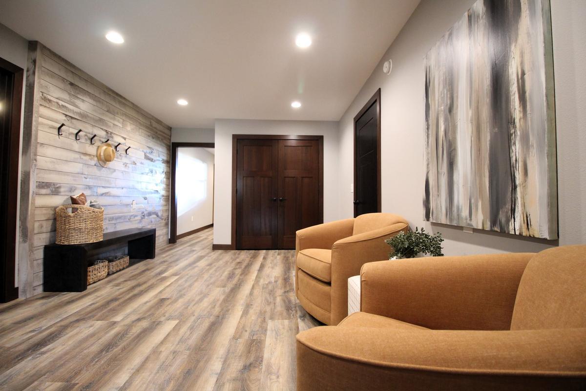Transitional entry space with plank wall and decor seating by Ross Construction in Wausau, WI.
