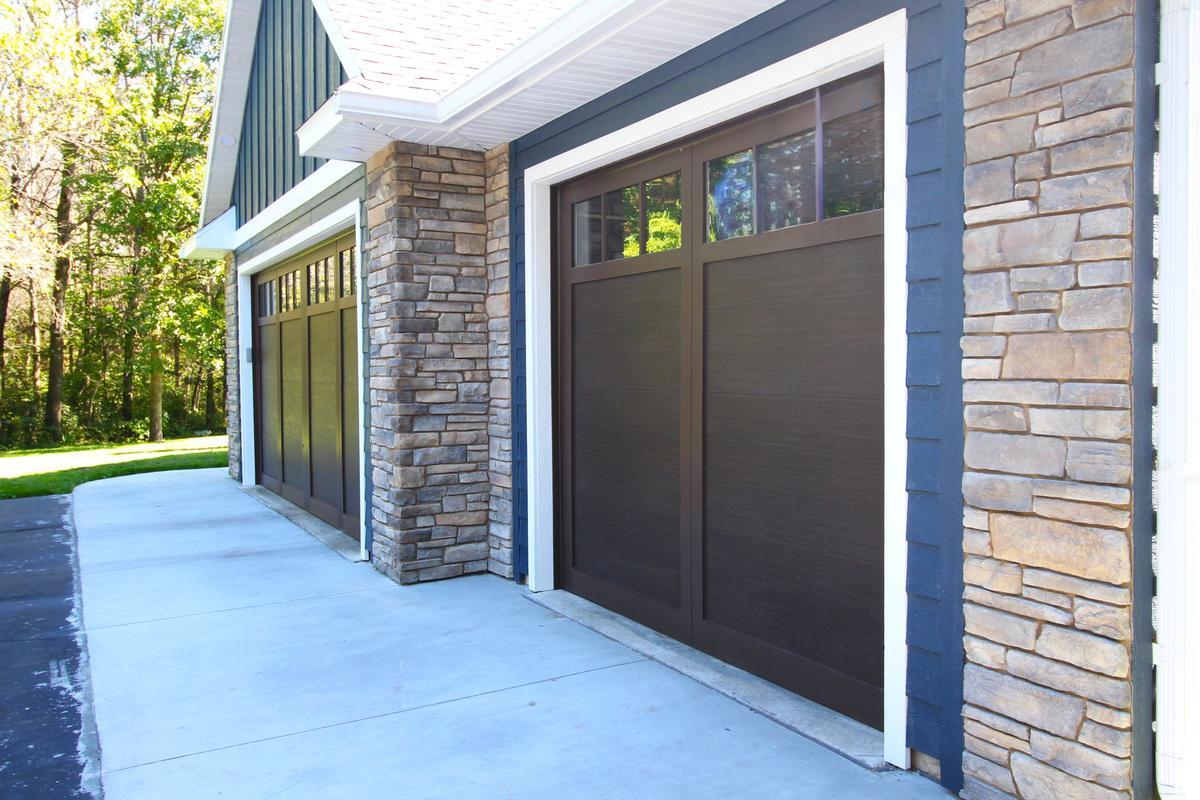 Close-up of stone and dark wood garage doors on Ross Construction custom home in Marathon, WI