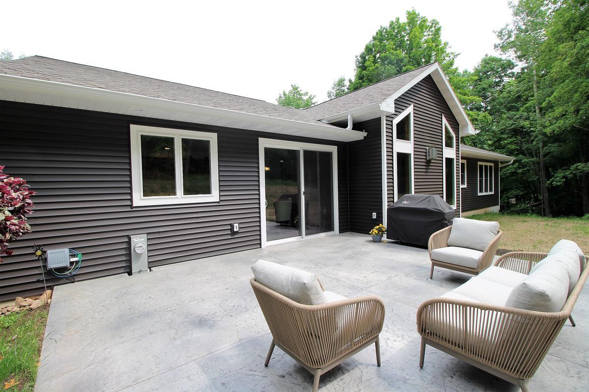 Gray concrete backyard patio at custom-built home by Ross Construction in Marathon, WI